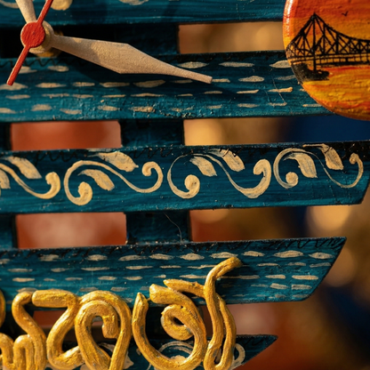 Decorative wooden object with blue and gold patterns, featuring a clock face and bridge design.