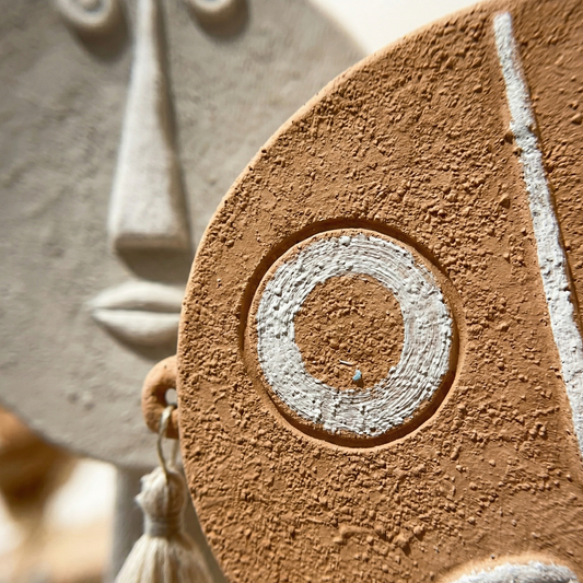 Close-up of a textured ceramic mask with circular design