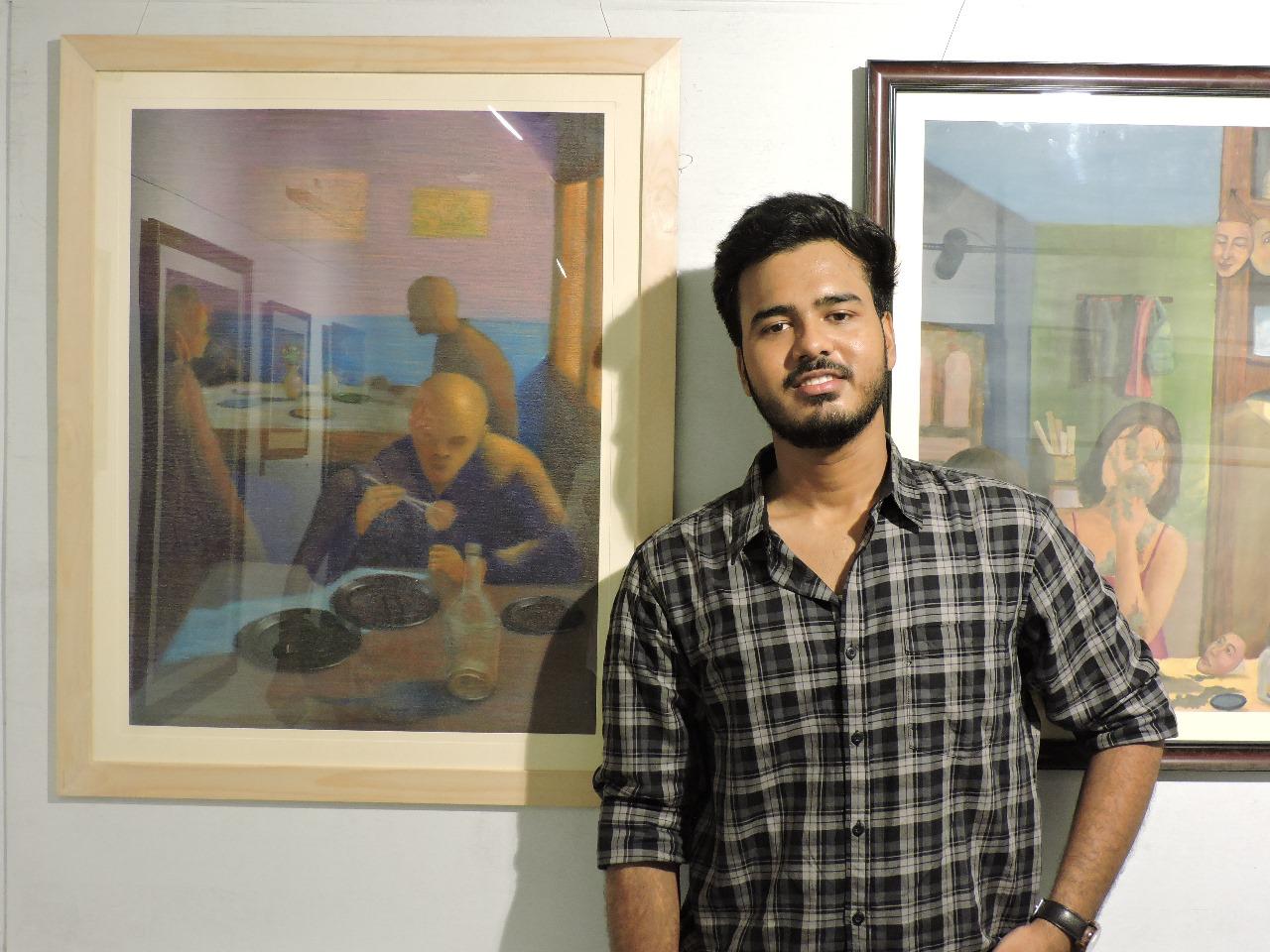 Man standing between two framed paintings on a wall