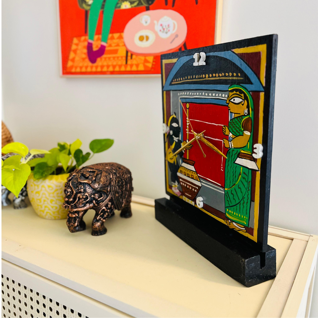 wooden table clock displayed on top of shelf to showcase the jamini roy art featuring krishna and yashoda
